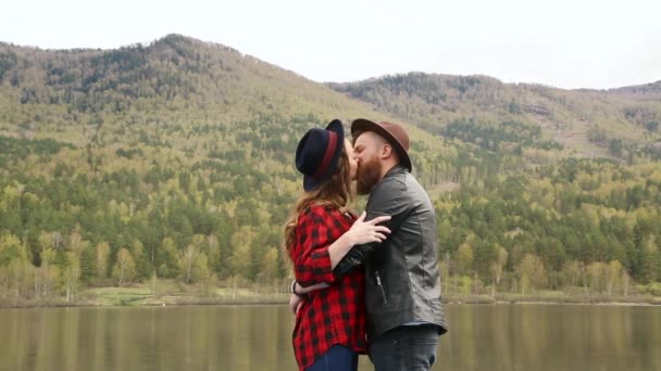 Hombre mujer riendo y besándose cerca de río y montaña. En verano — Vídeos de Stock