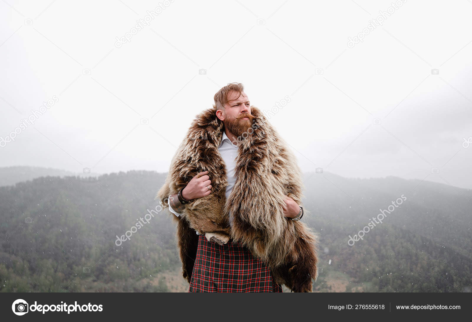 Man with mustache beard bear with a tattoo is standing mountain