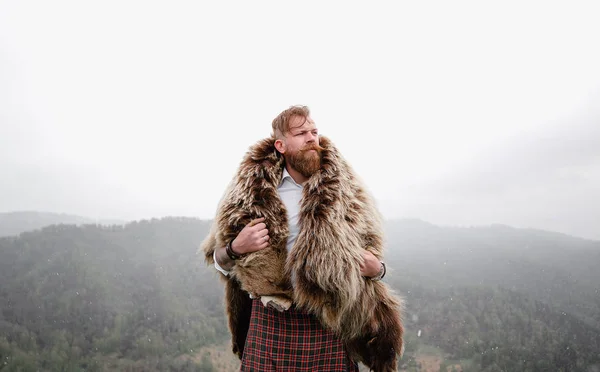 Man with mustache beard bear with a tattoo is standing mountain caucasian — Stock Photo, Image