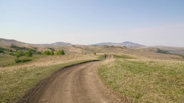 Homme avec moustache barbe marche le long de la route de campagne près des montagnes . — Video