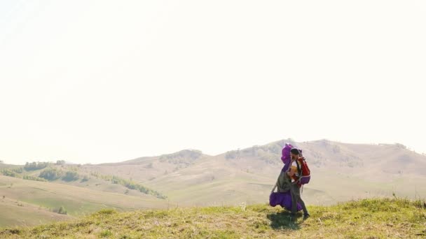 Ο άνθρωπος μούσι μουστάκι κουβαλάει ένα αλεξίπτωτο σε ένα φόντο βουνών — Αρχείο Βίντεο