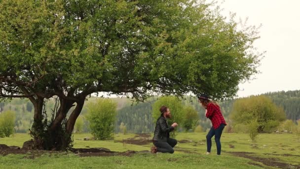 Мужчина признается в любви женщине под зеленым деревом. в лесу . — стоковое видео