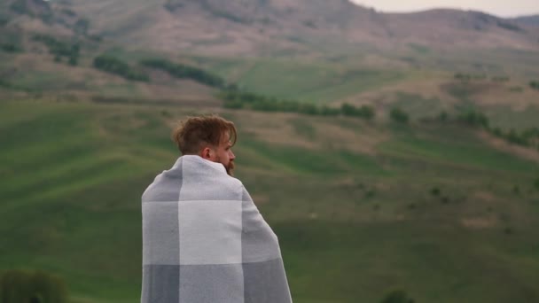 L'homme s'est enveloppé dans une plie et regarde autour de lui . — Video