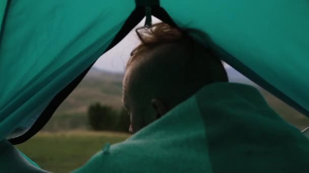 Mann guckt Zelt auf einem Berg — Stockvideo