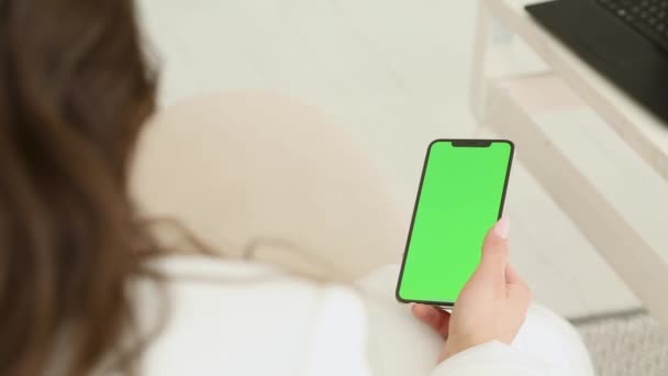 Menina morena folheando através de fotos telefone, tela verde, hromakey — Vídeo de Stock