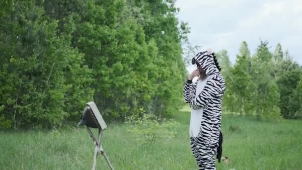 Hombre en un traje de cebra, con una cara pintada, emoción brillante, saltando en el bosque , — Vídeos de Stock