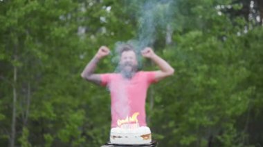 Doğum günü çocuğu sevinçle zıplar, ellerini pastanın önünde sallar, tatil kavramı