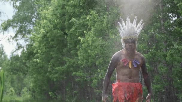 Hombre en tocado indio americano nativo realiza en el humo y el polvo, tiempos primitivos — Vídeo de stock