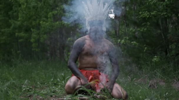 원주민 인디언 들의 머리 장식을 하고 있는 사람들은 원시 시대에 불을 피운다 — 비디오