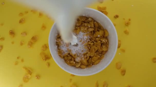 Close-up shot, Breakfast Cereal in a white bowl, Milk pouring into a bowl of cornflakes, — Stock Video