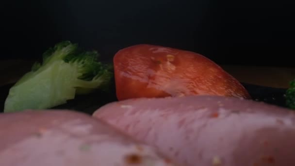 Крупним планом камера повільно рухається між овочами і сирою куркою, водяні бризки — стокове відео