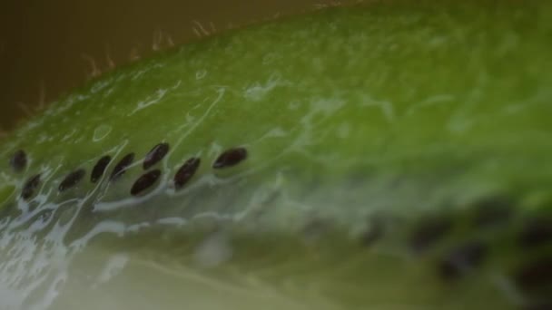 Kiwi frukt makro skytte, isolerade halv kiwi på gul bakgrund roterar — Stockvideo