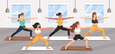 Yoga dersi uygulayan genç sportif kadınlardan oluşan bir grup. Kızlar virabhadrasana savaşçı yoga poz yapıyor.