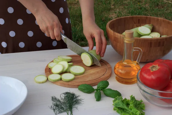 女性の夏の屋外地中海野菜サラダを調理 — ストック写真
