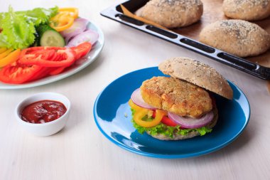 Nohut ile sağlıklı vejetaryen burger börek, sebze ve kepekli çörek susam ve kahvaltı için beyaz masa üzerinde haşhaş tohumu ile. Yemek, yemek tarifi
