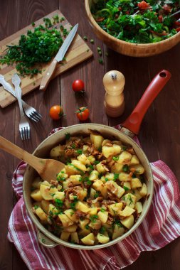 Bir tavada kahverengi ahşap bir masa üzerinde Cantharellus cibarius mantar patates pişmiş. Sağlıklı vegan gıda