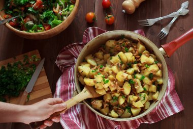 Bir tavada kahverengi ahşap bir masa üzerinde Cantharellus cibarius mantar patates pişmiş. Sağlıklı vegan gıda