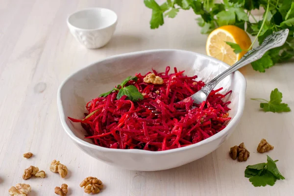 Havuç ve ceviz Beyaz ahşap masa üzerinde bir kase ile sağlıklı çiğ vegan pancar salatası. Doğal organik gıda kavramı. Sağlıklı beslenme