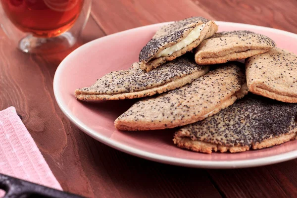 Kuark, süzme peynir, kuru üzüm, sochni ya da sochniki turtası ya da pembe tabakta haşhaş tohumlu pirozhki ve kahverengi ahşap masa üzerinde çay ile geleneksel Rus tatlısı.