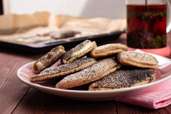 Kuark, süzme peynir, kuru üzüm, sochni ya da sochniki turtası ya da pembe tabakta haşhaş tohumlu pirozhki ve kahverengi ahşap masa üzerinde çay ile geleneksel Rus tatlısı.