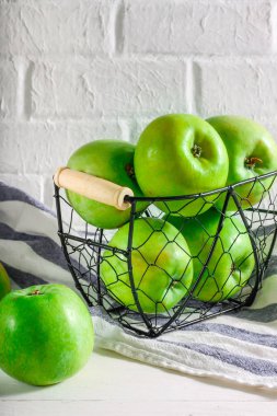 Beyaz arka plan üzerinde metal bir sepet içinde yeşil elma. Doğal beslenme, taze meyve. Diyet.