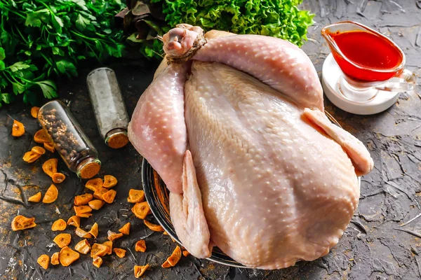 Fresh chicken for baking in a dish, with marinade, garlic flakes, spices and herbs. Raw chicken is an ingredient for cooking. Chicken for baking on Independence Day.