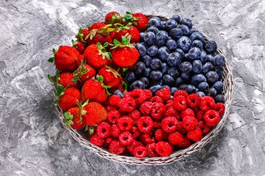 Beton bir arka plan üzerinde taze çilek ile Sepet - çilek yaz hasat. 