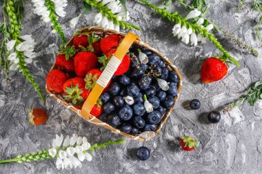 Beton bir arka plan üzerinde taze çilek ile Sepet - çilek yaz hasat. 