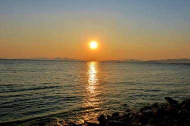 güzel Yunanistan'da denizde kırmızı ve pembe gün batımı