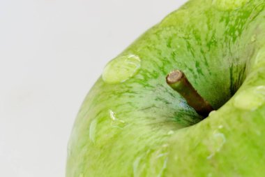 yağmurdan sonra su damlaları ile beyaz bir arka plan üzerinde olgun yeşil elma