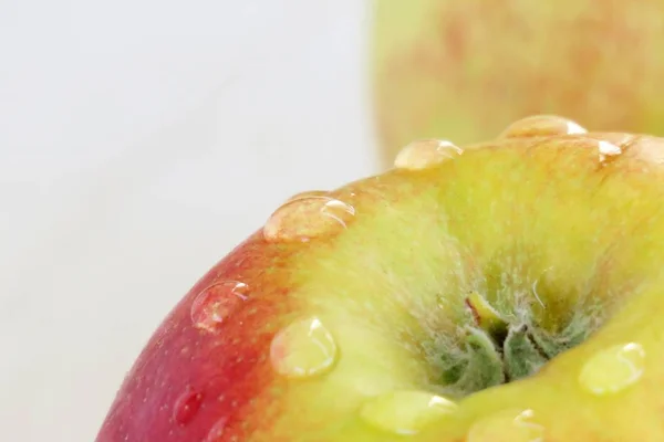 ripe red - yellow apple on a white background with drops of water after rain