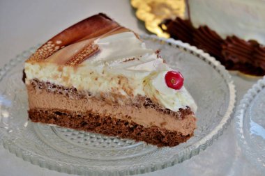  küçük bir tabak üzerinde üç farklı tabakadan oluşan bir parça pasta