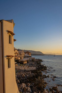 Cefalu 'nun kayalık sahillerinden gün batımı manzarası 