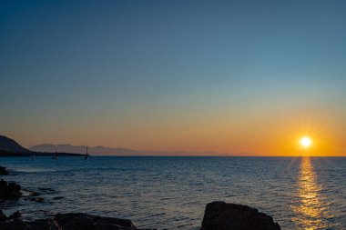 Cefalu 'nun kayalık sahillerinden gün batımı manzarası 