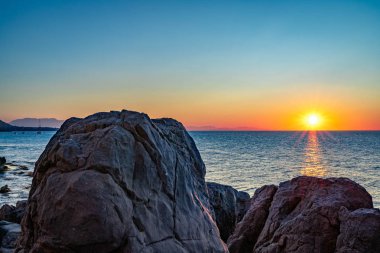 Cefalu 'nun kayalık sahillerinden gün batımı manzarası 