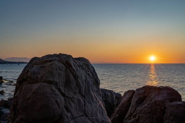 Cefalu 'nun kayalık sahillerinden gün batımı manzarası 