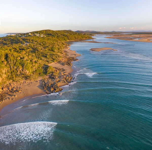 Hermosa imagen aérea de un pueblo costero con pequeña playa y suaves olas azules — Foto de Stock