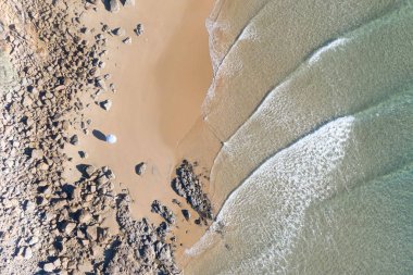 Güzel dalgalar hatları, sığ turkuaz su ile gün doğumunda bir plaj Top güzel görünümü
