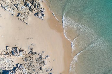 Güzel dalgalar hatları, sığ turkuaz su ile gün doğumunda bir plaj Top güzel görünümü