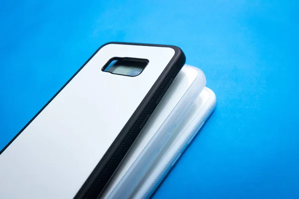 鮮やかな青い紙の背景にスマートフォンケースのバックビュー あなたのデザインのための3つの電話カバーまたはプロテクター — ストック写真