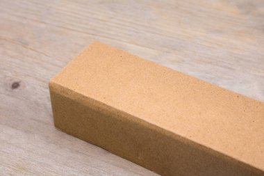 Ahşap masa arka plan üzerinde karton kutu. Tasarımınız için uzun kutu şablonu. Geri dönüştürülmüş ürün ambalajı.