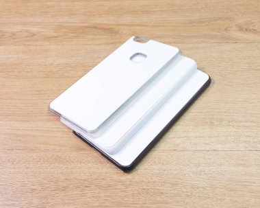 Modern konseptte ahşap masa üzerinde boş telefon kılıfları. Montaj veya tasarımınız için boş mobil kapak.