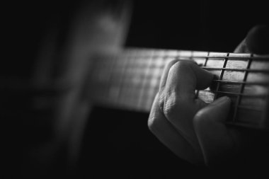 Bellek arka planda akustik gitar çalan elin yakın.