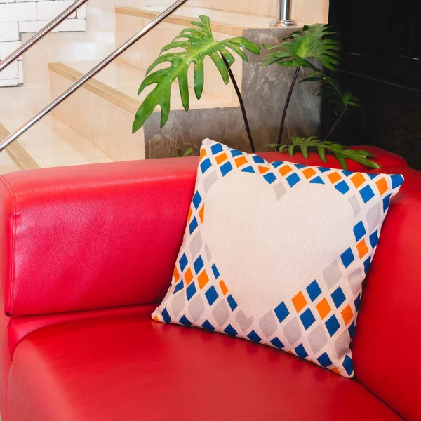 Colorful modern design pillow put on red luxury sofa. Beautiful decoration house object of relax or rest.