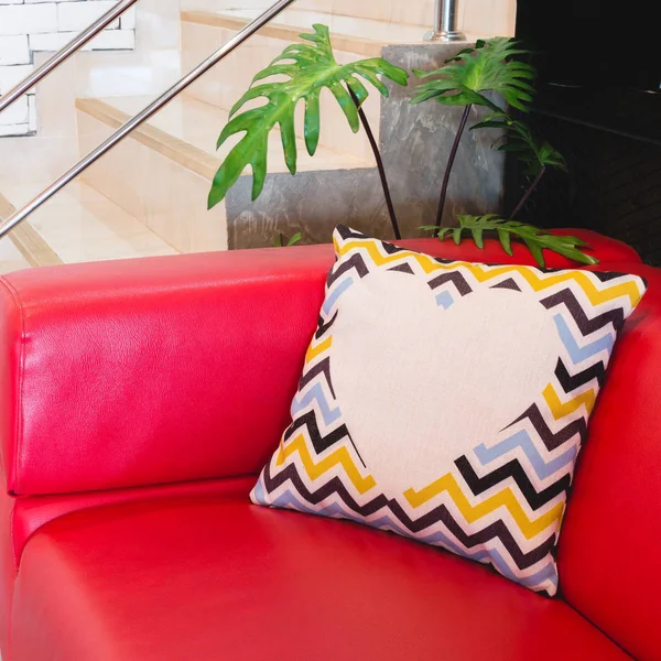 Colorful modern design pillow put on red luxury sofa. Beautiful decoration house object of relax or rest.