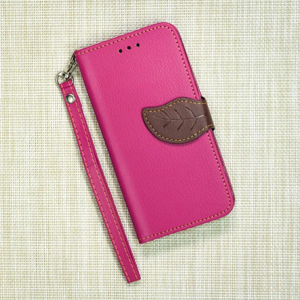 Pink leather phone case on weave background. Fashion mobile phone cover.