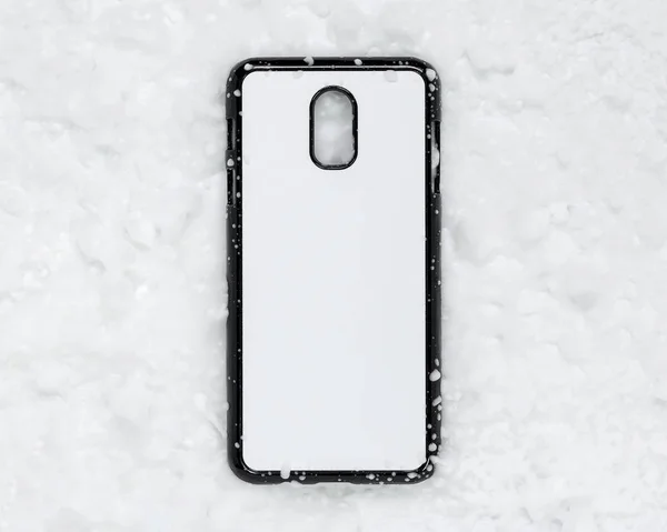 雪のテクスチャの背景に黒のモバイルカバー 印刷用の電話ケースと白い表面 — ストック写真