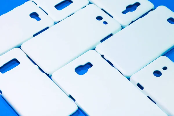 鮮やかな青の背景に白い電話ケース あなたのデザインのためのモバイルケースやスマートフォンプロテクター — ストック写真