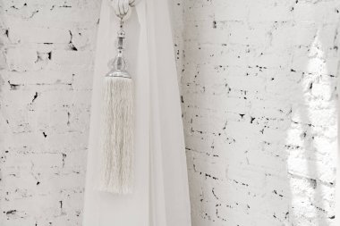 Beyaz tuğla arka plan üzerinde perde Püsküller.