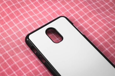 Pembe masa örtüsü arka plan üzerinde siyah mobil kapak. Tasarımınız için telefon kılıfının ve beyaz yüzeyin arka görünümü.